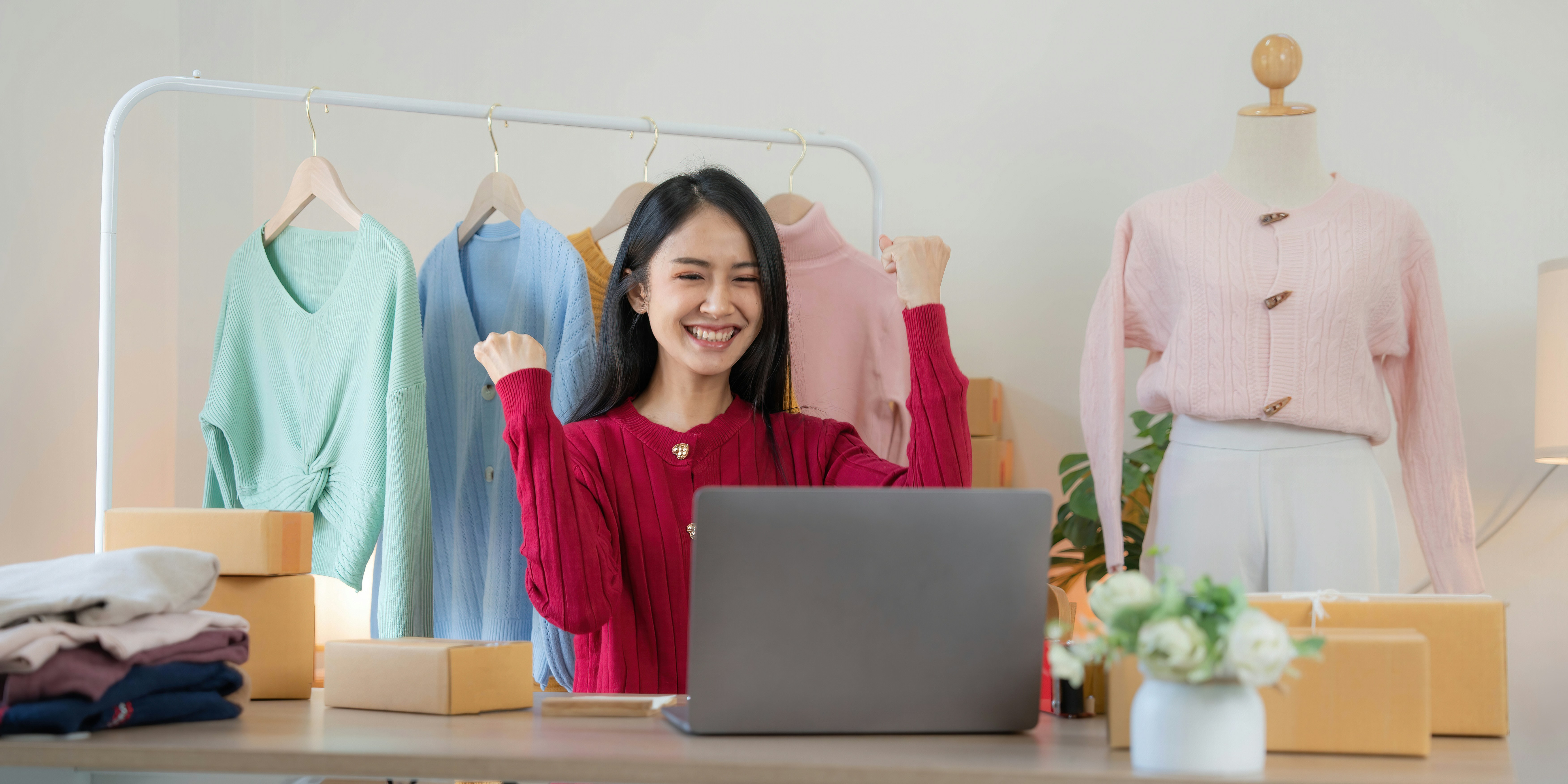 Pemilik bisnis online mengemas pesanan dengan laptop di sampingnya